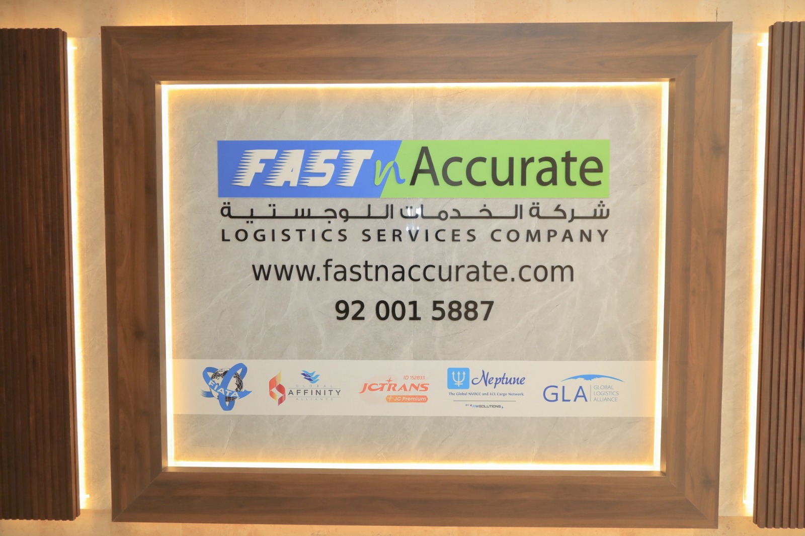 Fast n Accurate branded reception wall showing the company website and unified number